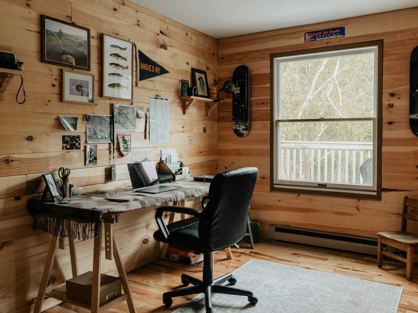 A wood-panelled home studio with a desk and a view