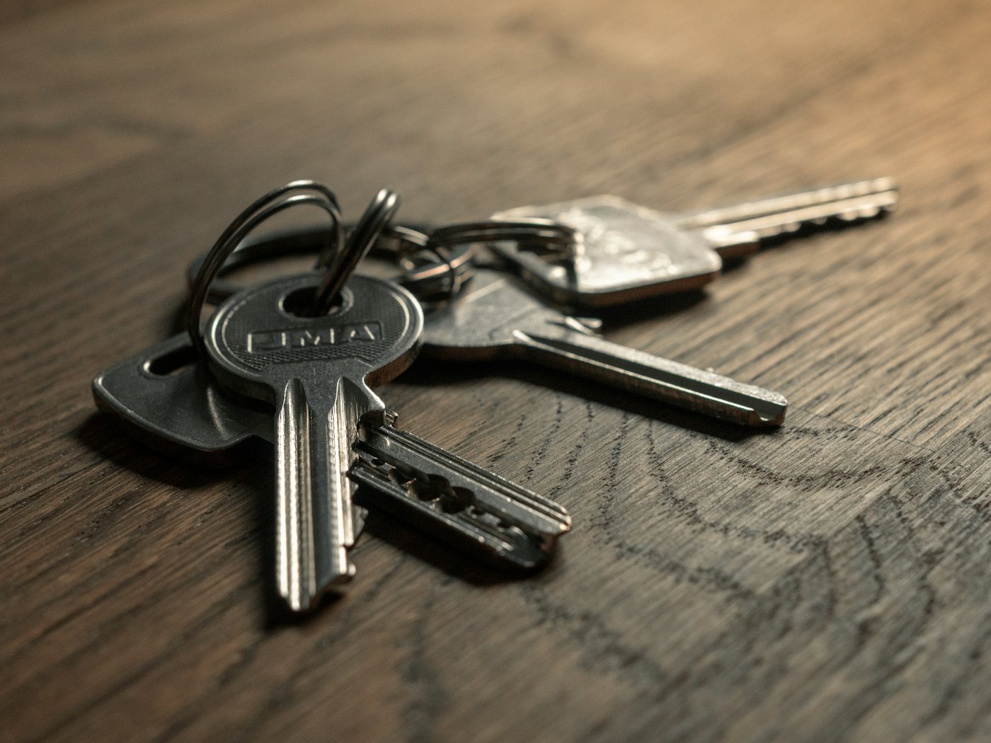 A bunch of keys on a wooden table