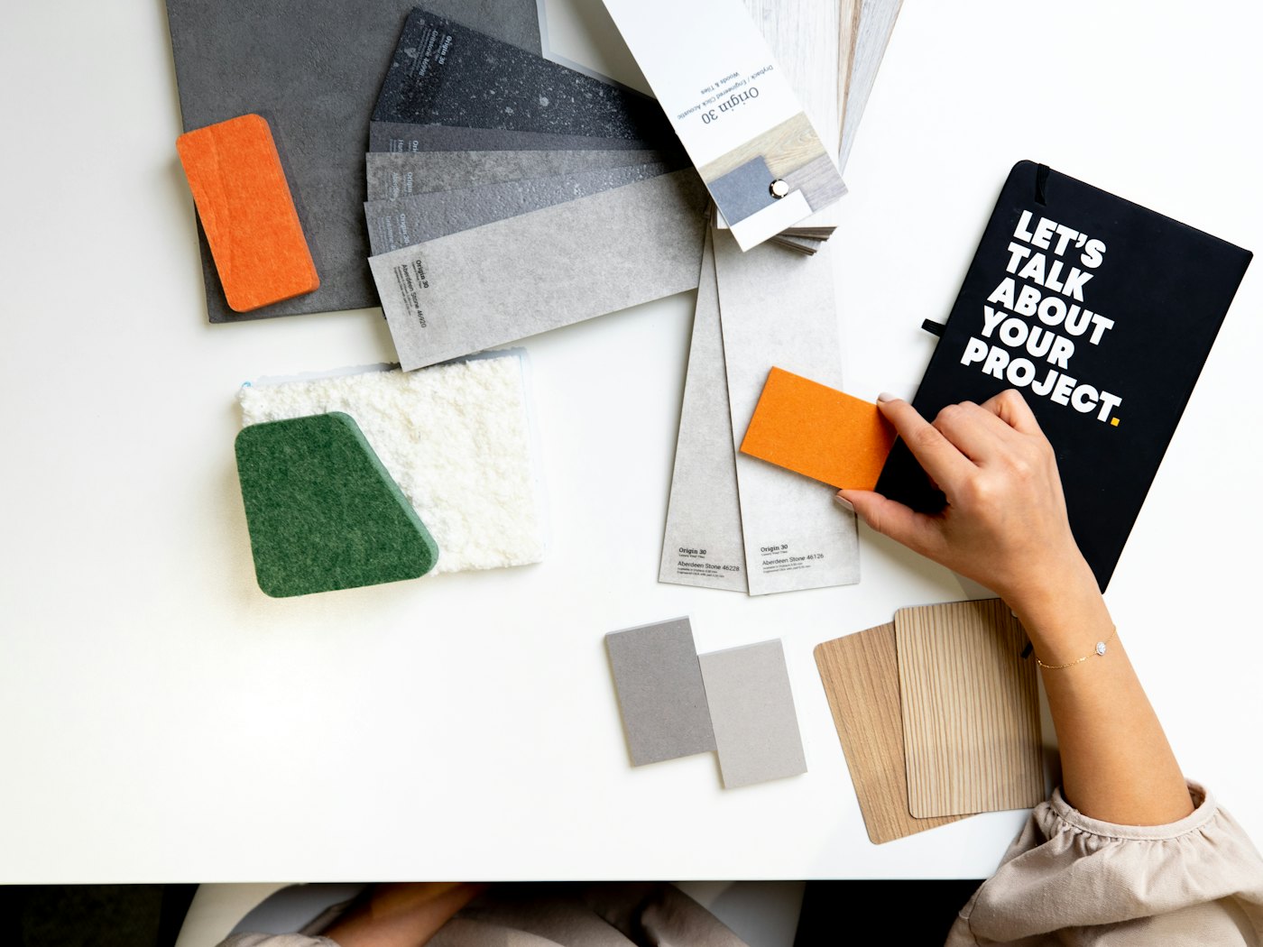 Material samples and a notebook laid out for a design project