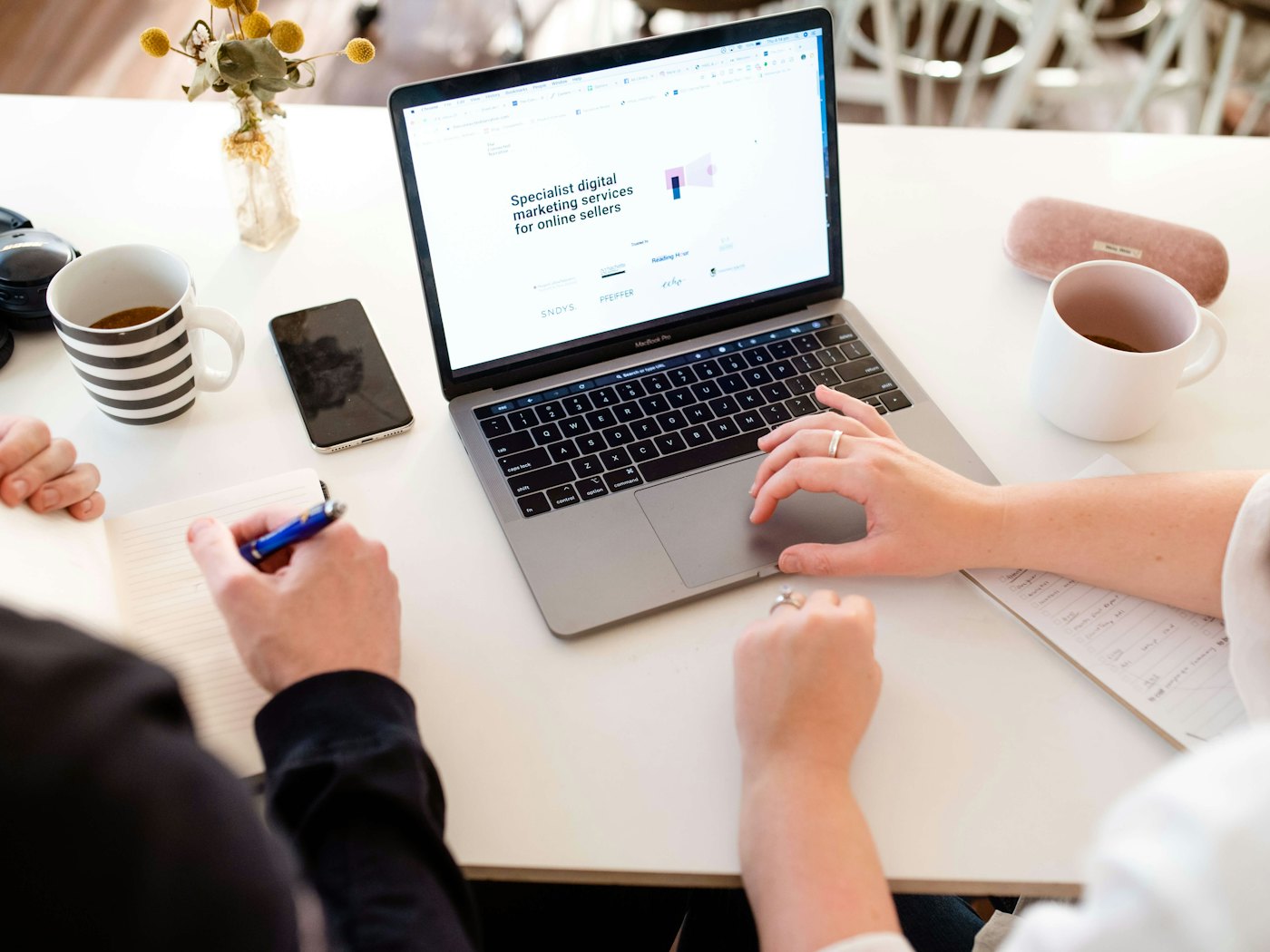 Two people reviewing a website together on a laptop
